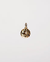 View from the side of the French Cruller Charm on light color background.