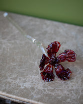 Alex Rosenbaum Red Glass Flower on green background.
