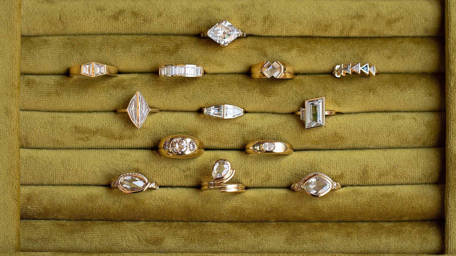 Closeup details of Mociun Collection and One-of-a-Kind Engagement & statement-right-hand-rings in a ring tray finished in chartreuse green velvet.
