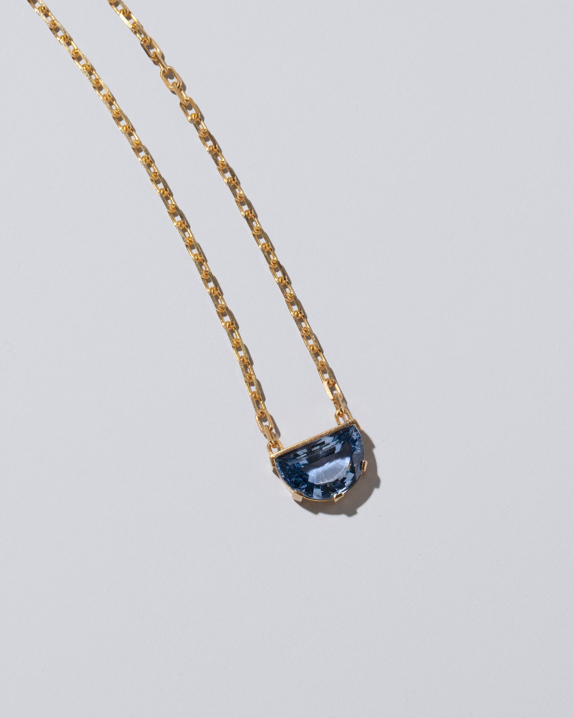 Closeup details of the Reverence Necklace on light color background.