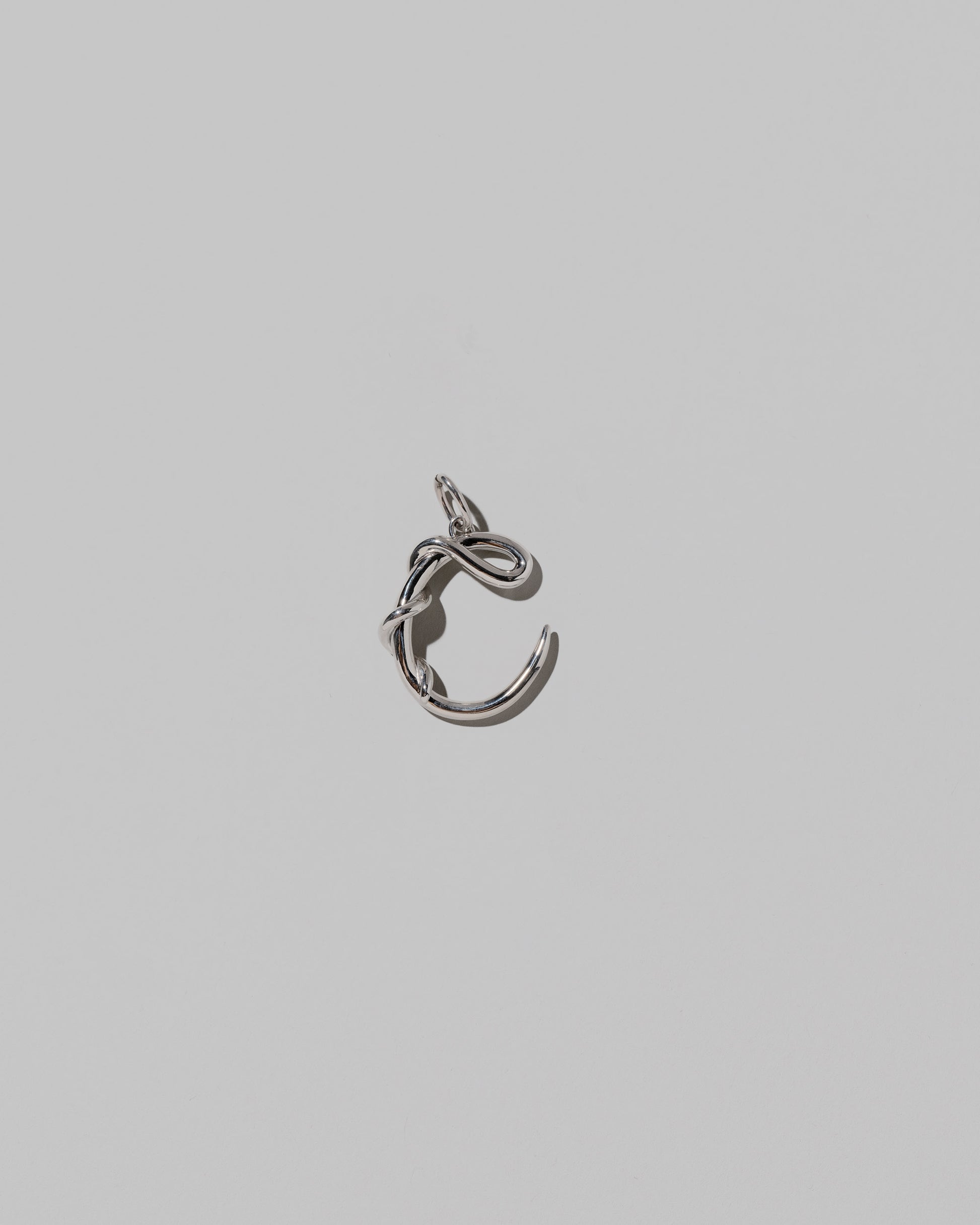 CRZM Medium Letter C Charm set in sterling silver on light color background.