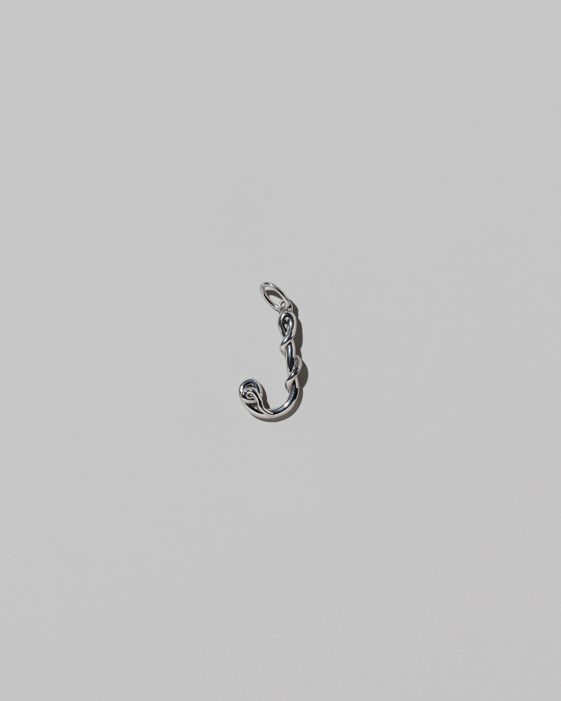 CRZM Medium Letter J Charm set in sterling silver on light color background.