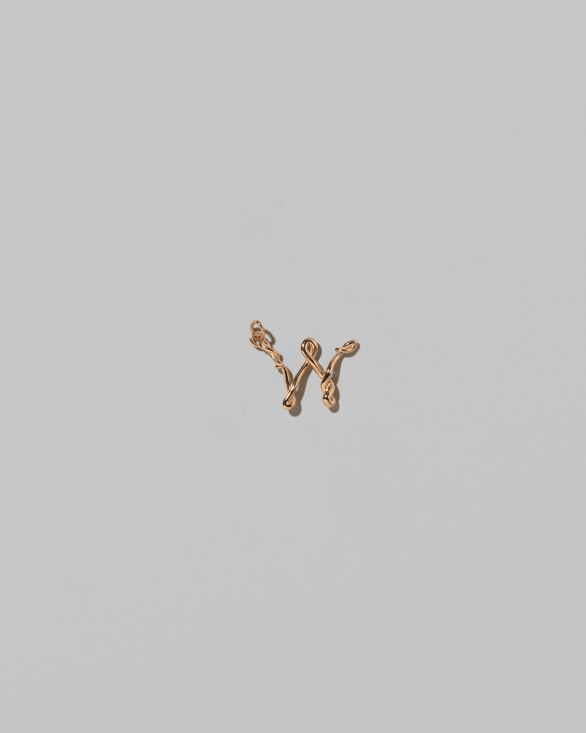 CRZM Mini Letter W set in solid gold on light color background.