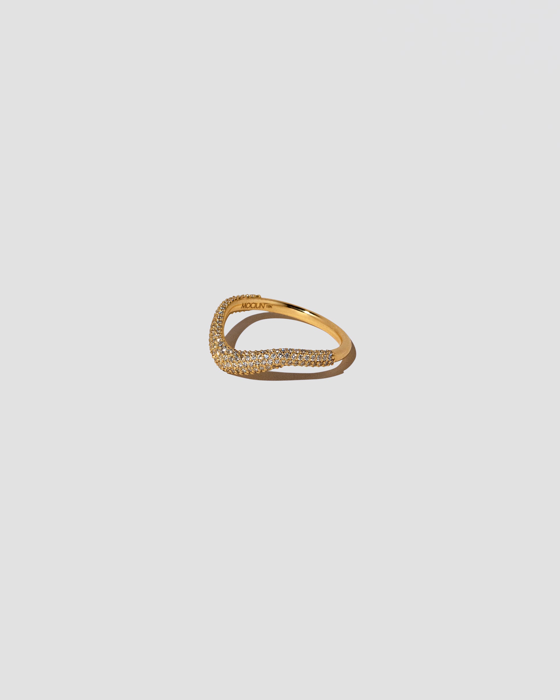 View from the side of the Gold Pavé Thin Level Band on light color background.