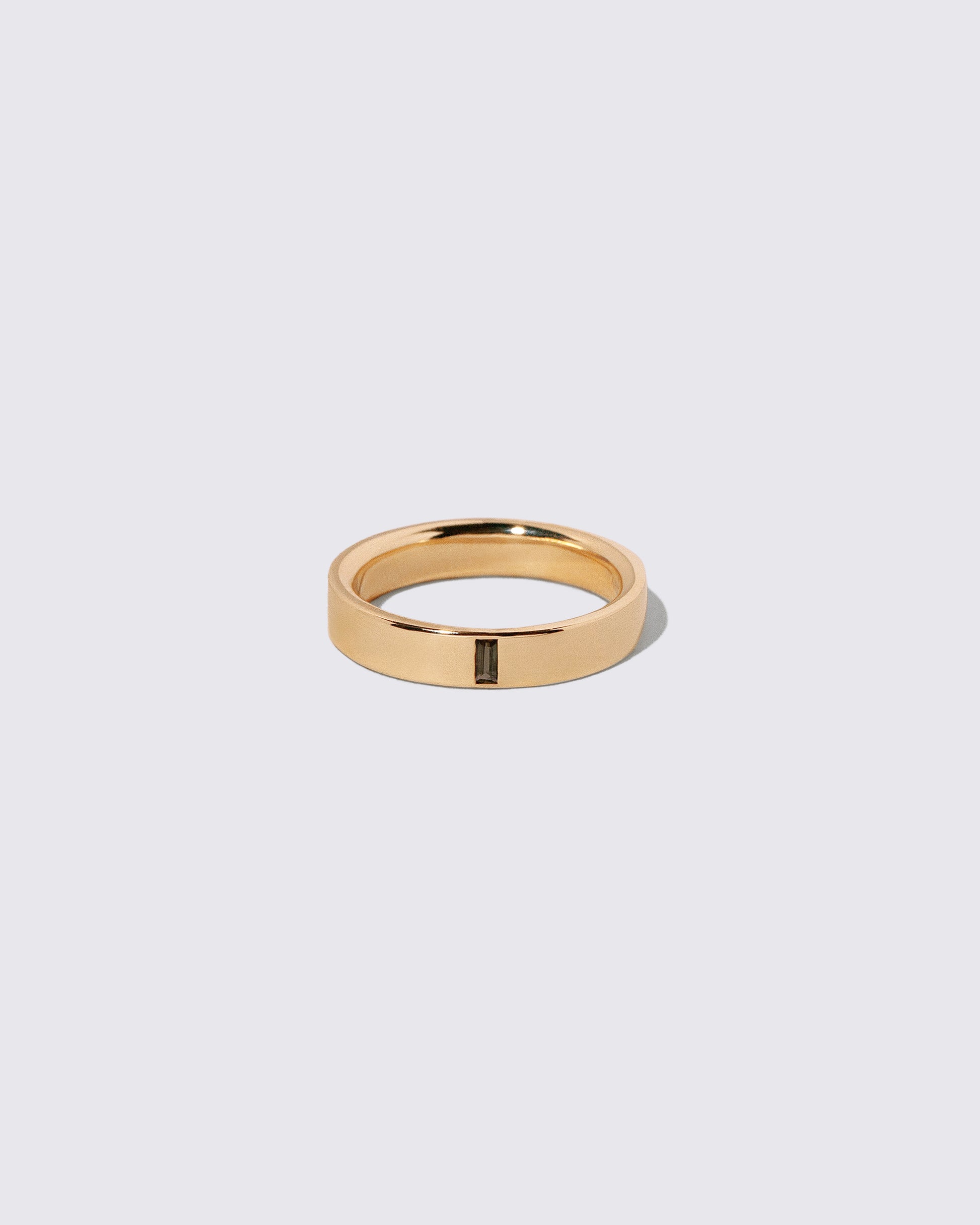 Gold Andalusite North South 4mm Baguette-Set Piet Band on light color background.