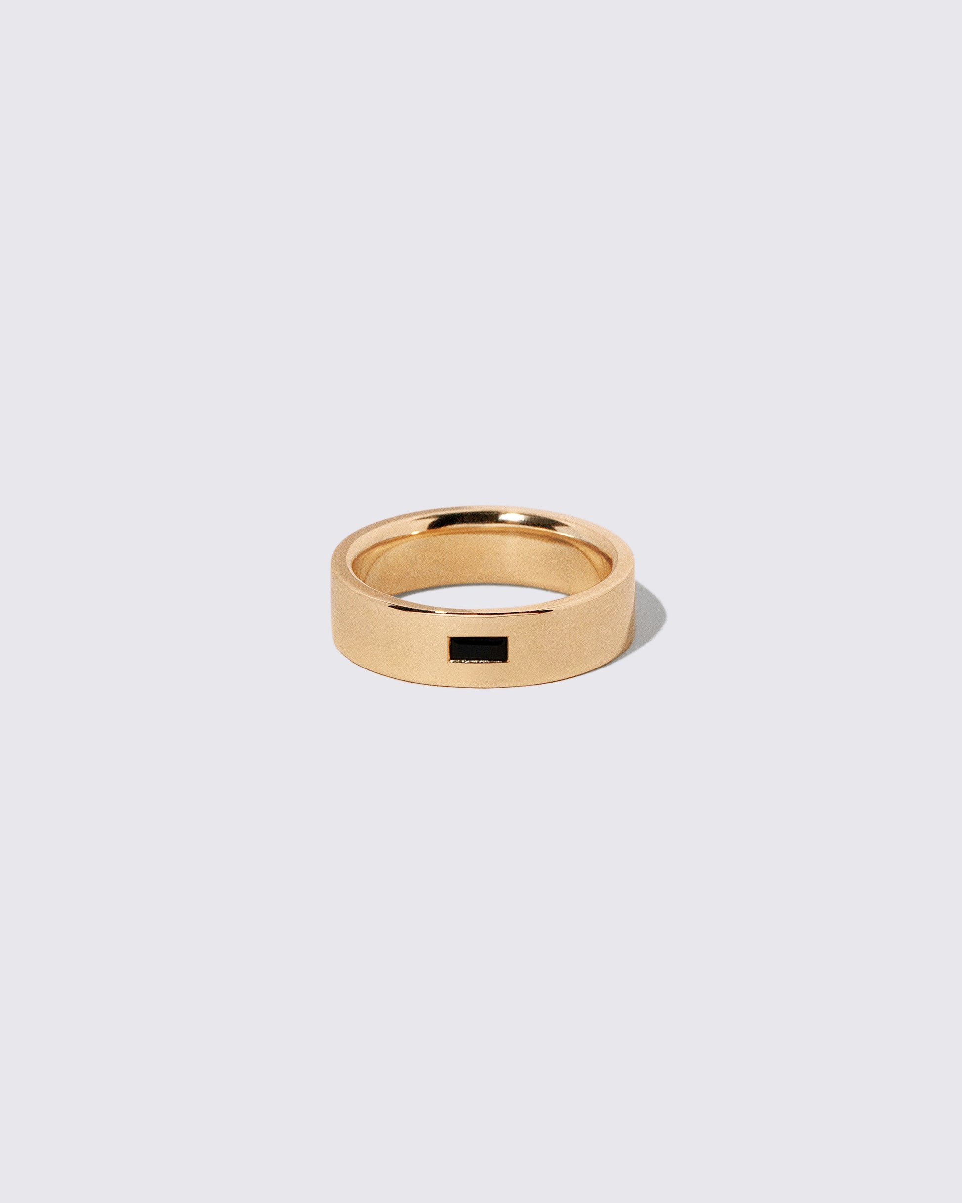 Gold Black Spinel East West 6mm Baguette-Set Piet Band on light color background.