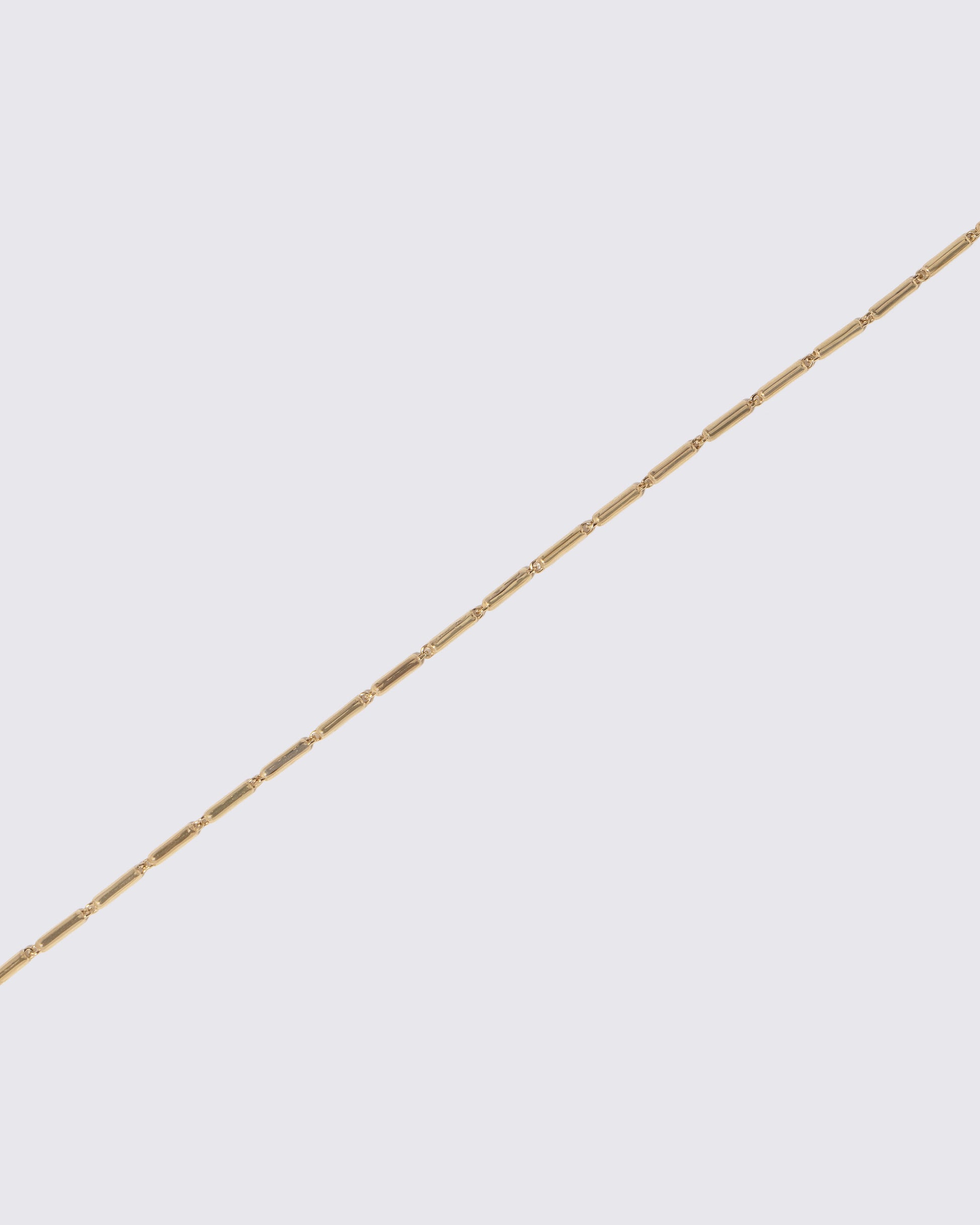 Closeup details of the Gold Butter Chain Bracelet on light color background.
