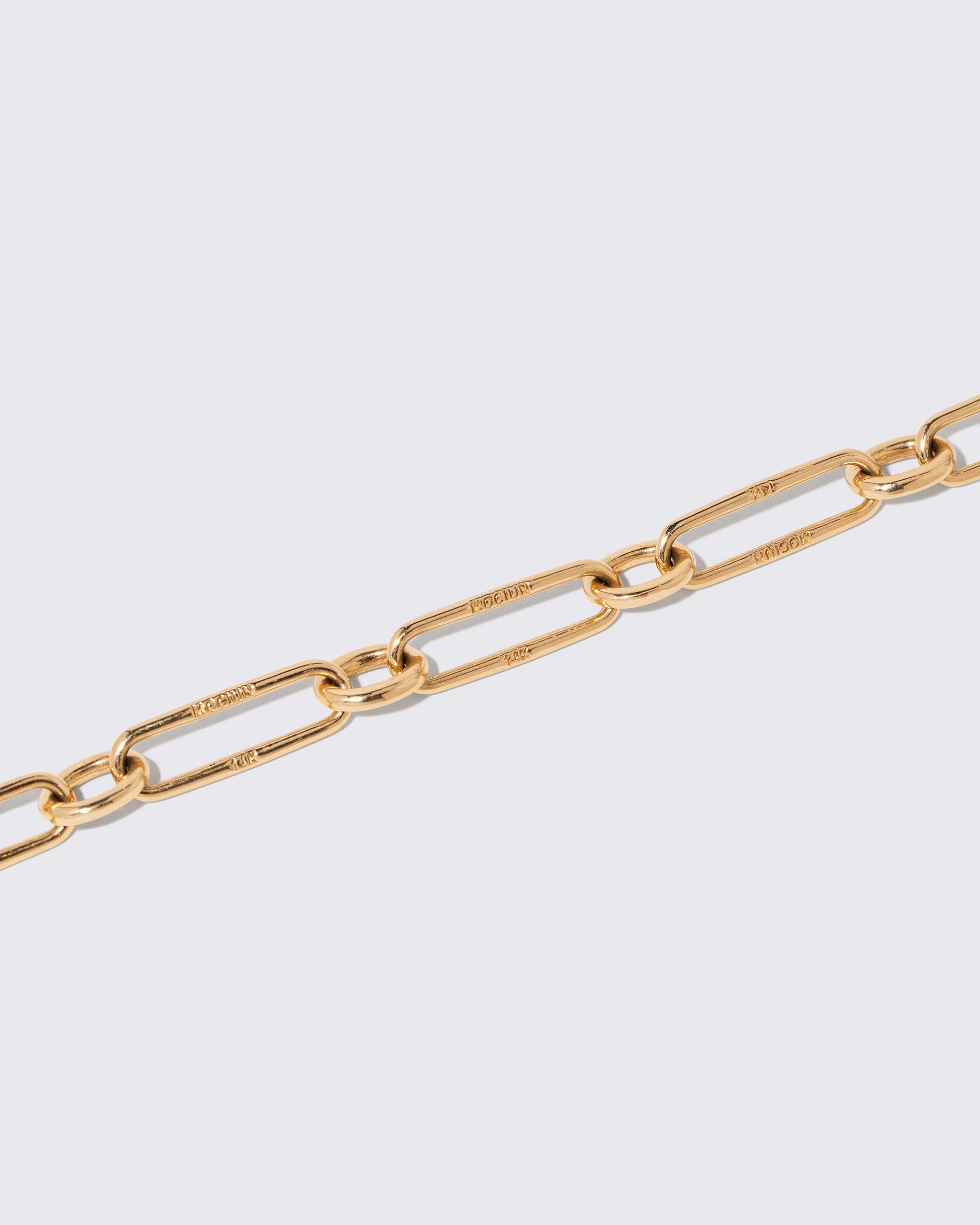 Closeup details of the Gold Link Bracelet on light color background.