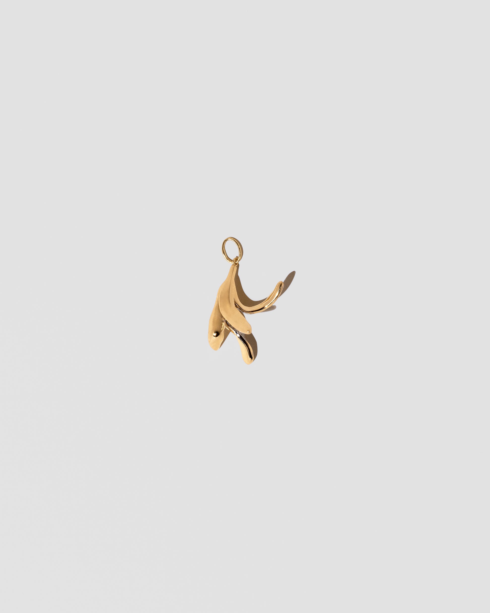 View from the back of the Banana Peel Charm on light color background.