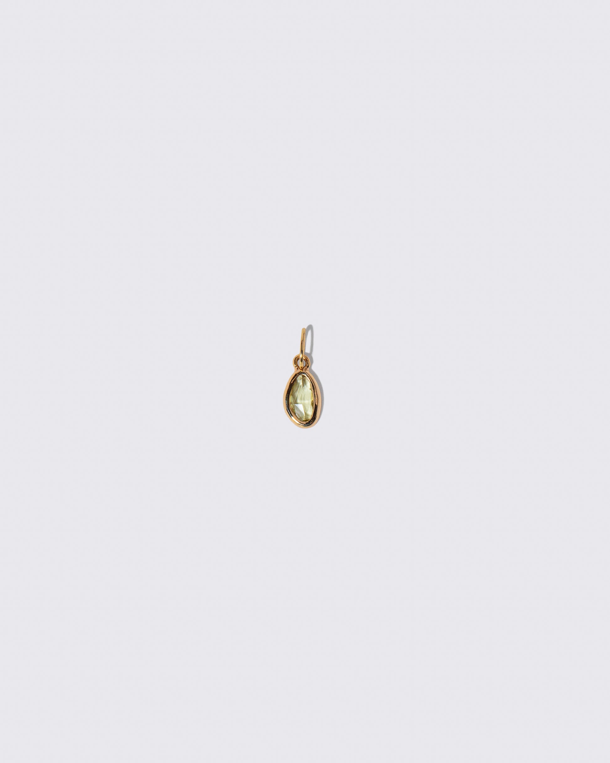 Yellow Sapphire Gusher Charm on light color background.