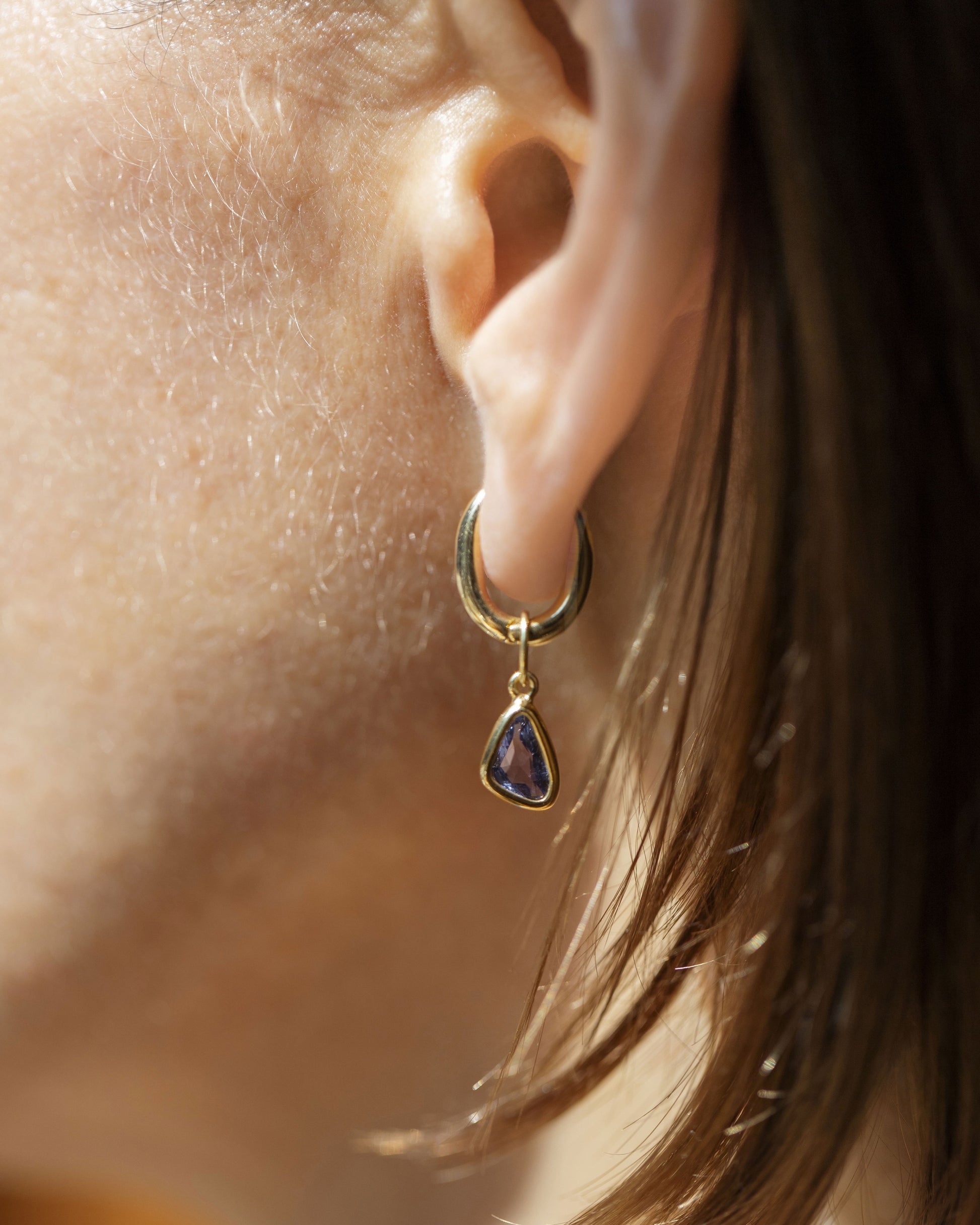 Styling Huggie Hoop Earring Single and Blue Sapphire Gusher Charm on model.