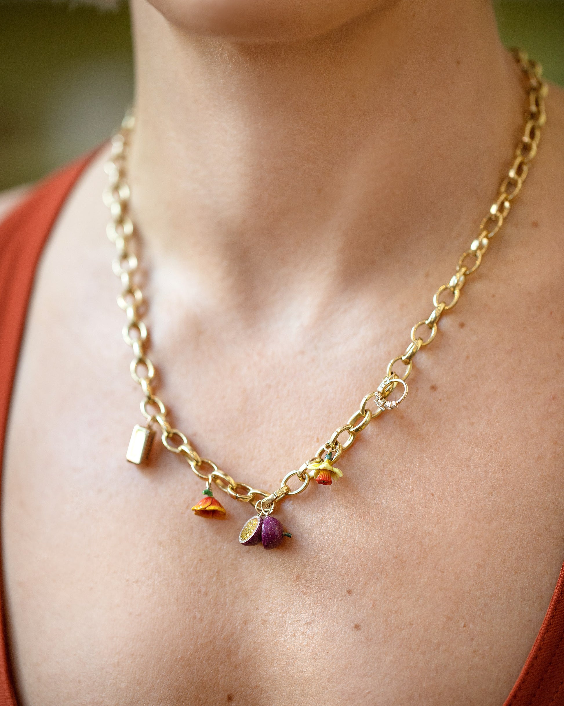 Stick of Salted Butter Charm, Halved Passion Fruit Charms, California Poppy Charm, Daffodil Charm and Luna Ring Charm paired with Gold Endless Clasp Bracelets worn as a a necklace on model