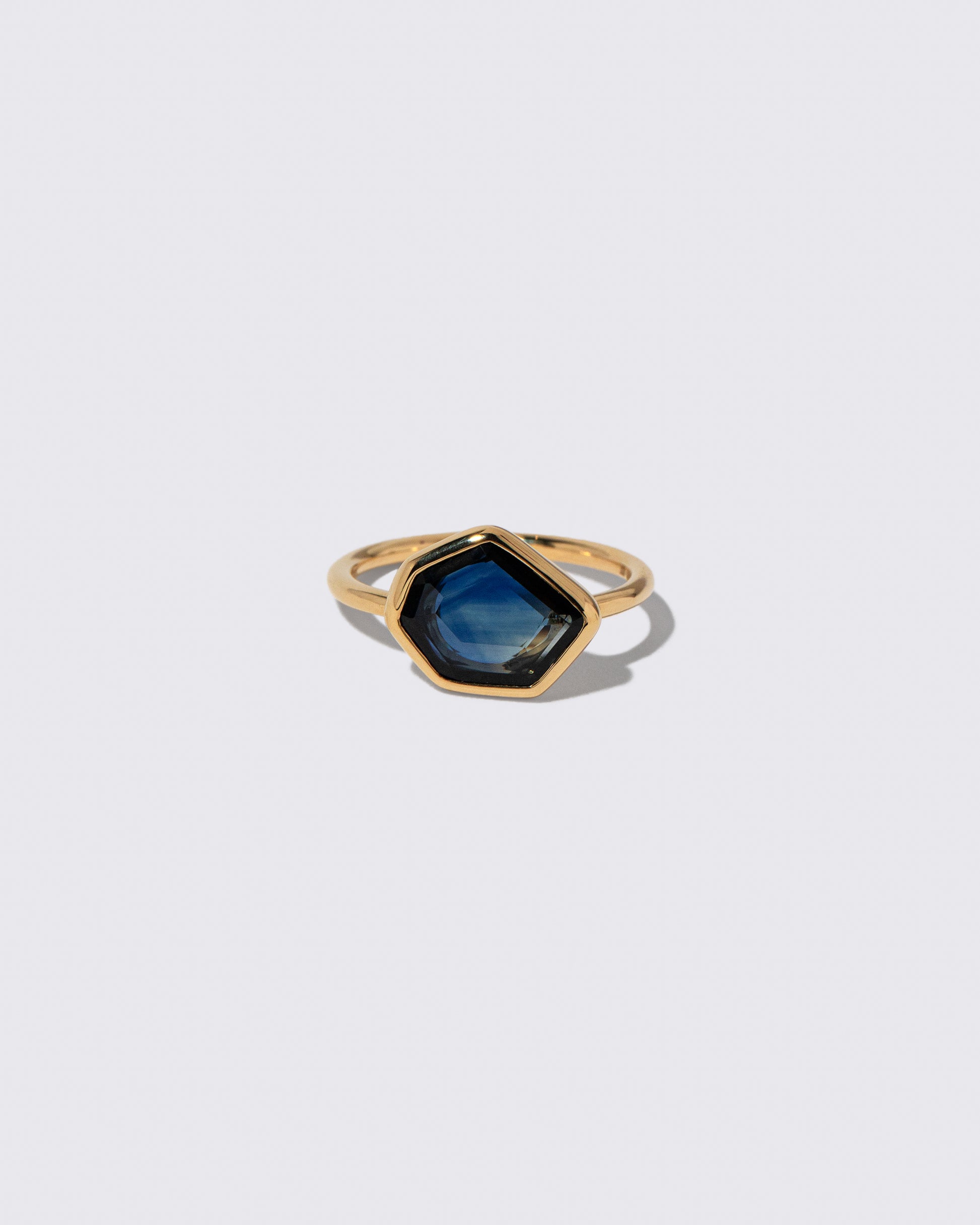 Teal Blue Sapphire Gusher Ring on light color background.