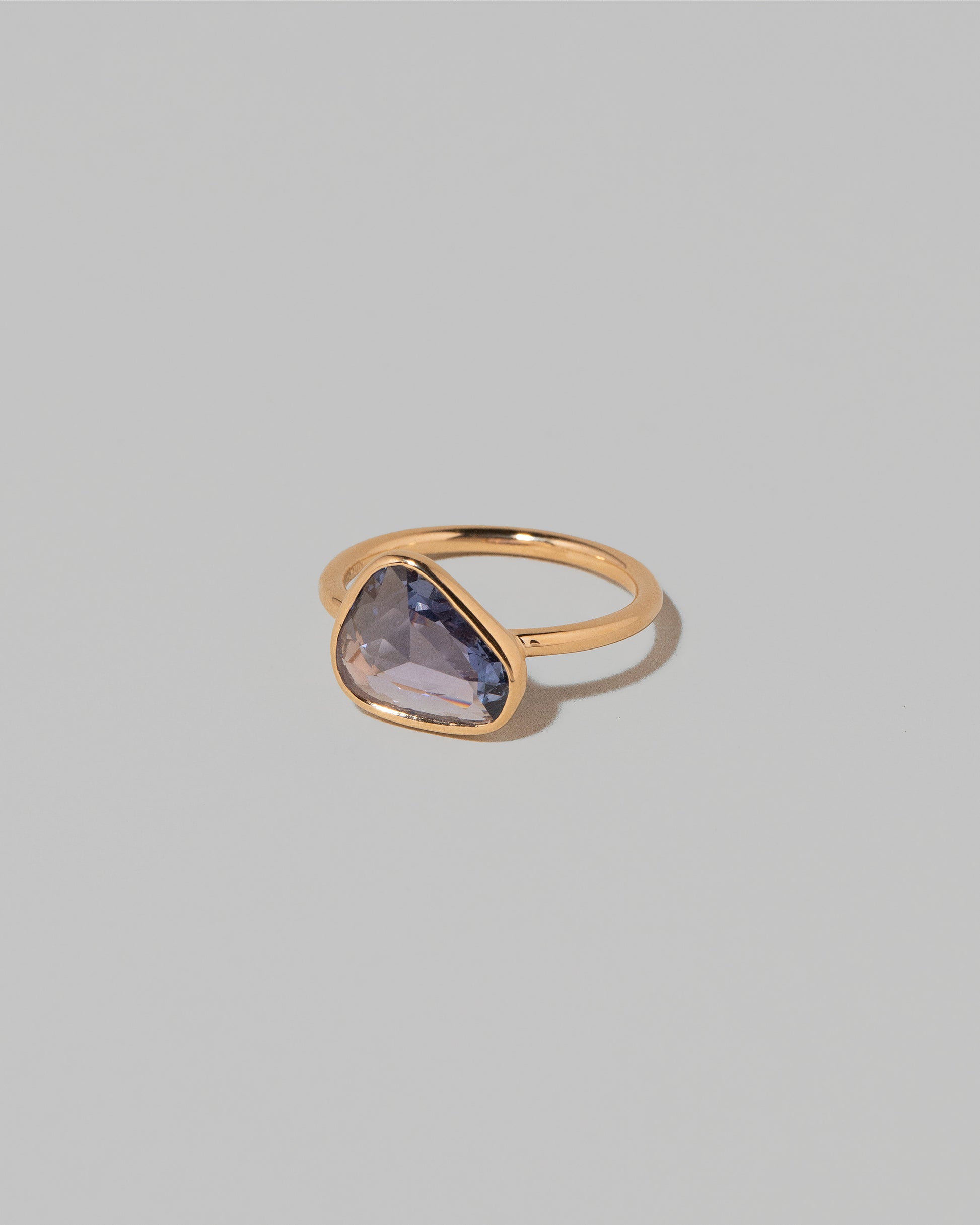View from the side of the Gusher Purple Sapphire Ring 001 on light color background.