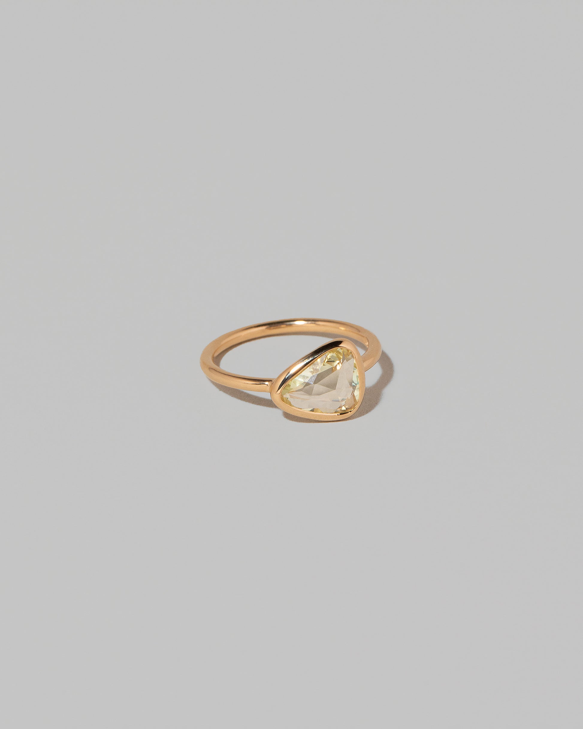 View from the side of the Gusher Chartreuse Sapphire Ring 003 on light color background.