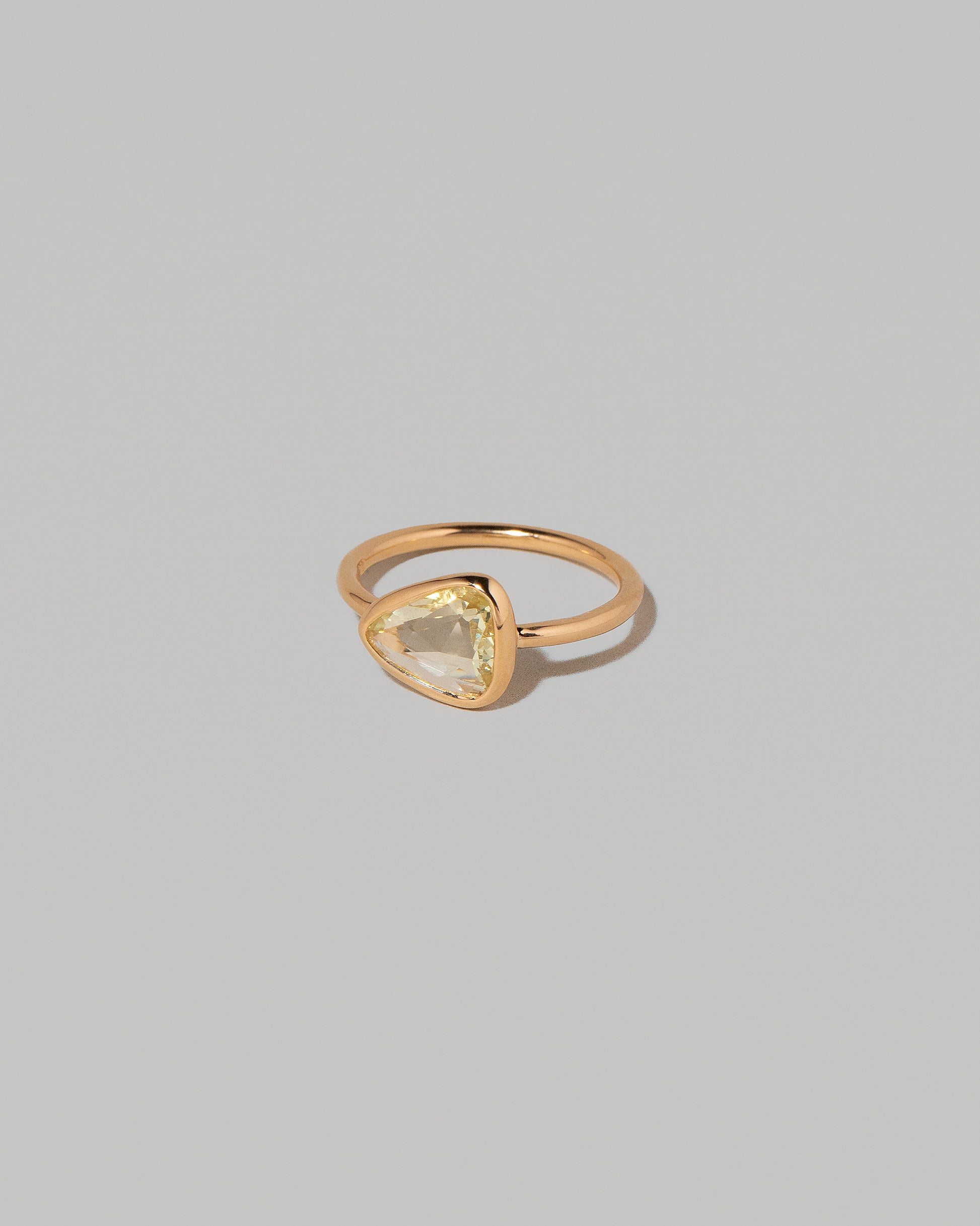View from the side of the Gusher Chartreuse Sapphire Ring 003 on light color background.