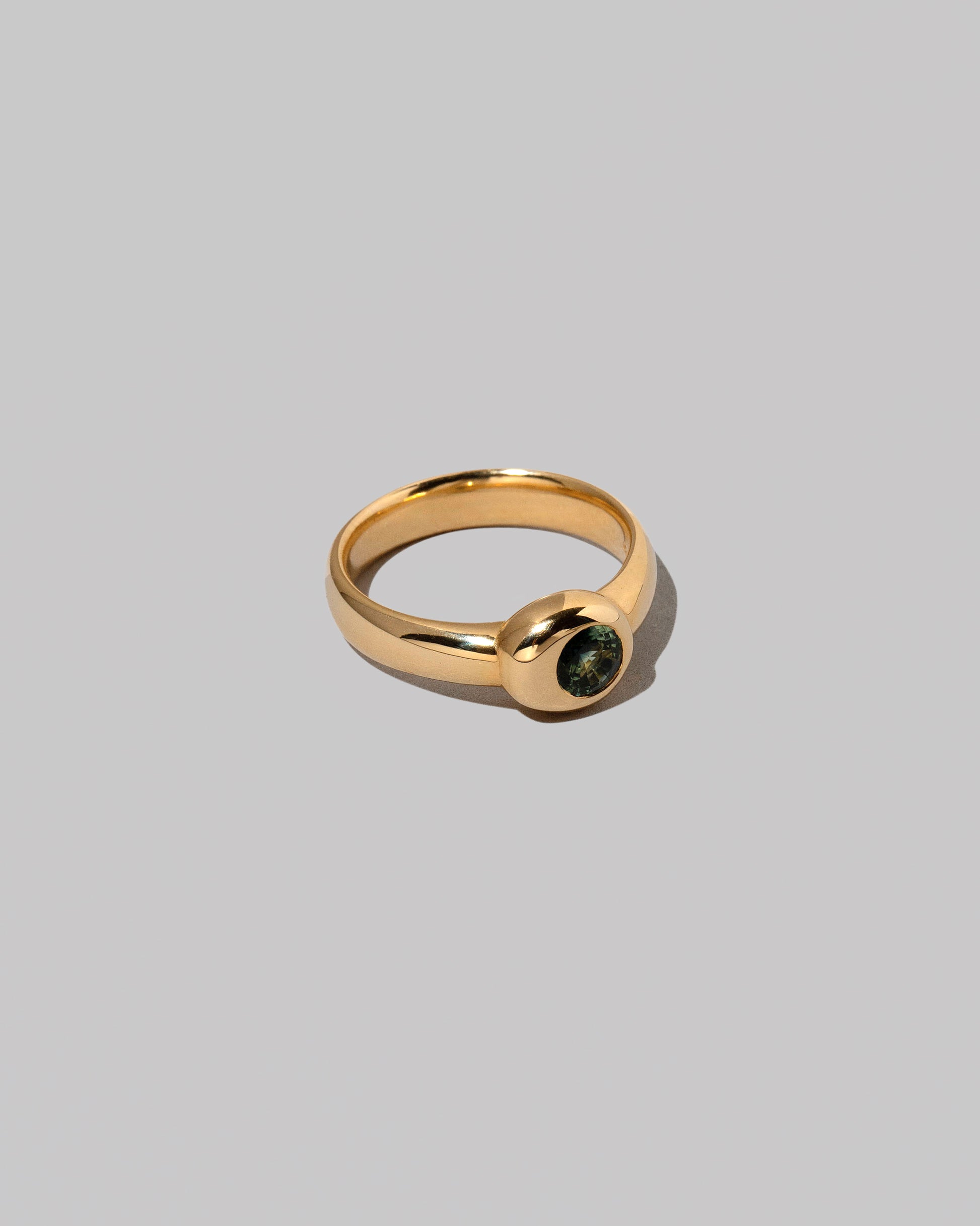View from the side of the Green Sapphire Level Ring on light color background.