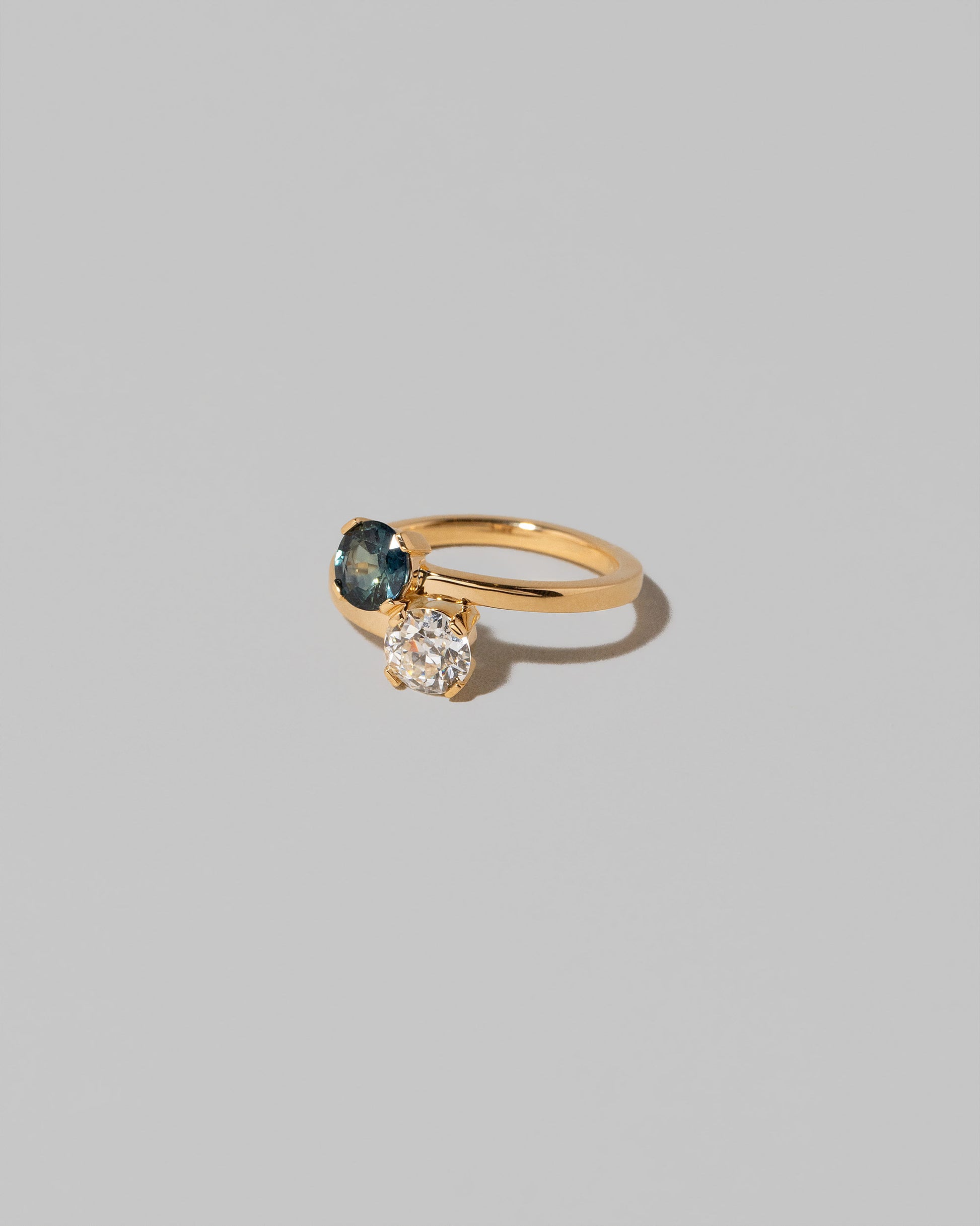 View from the side of the Sapphire & Diamond Union Ring on light color background.