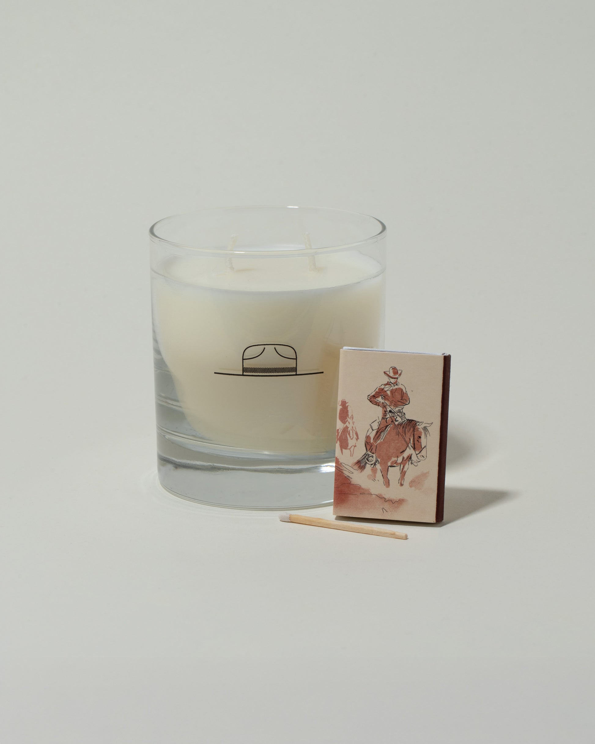 Closeup details of the Ranger Station Leather & Pine Candle with matchbox on light color background.