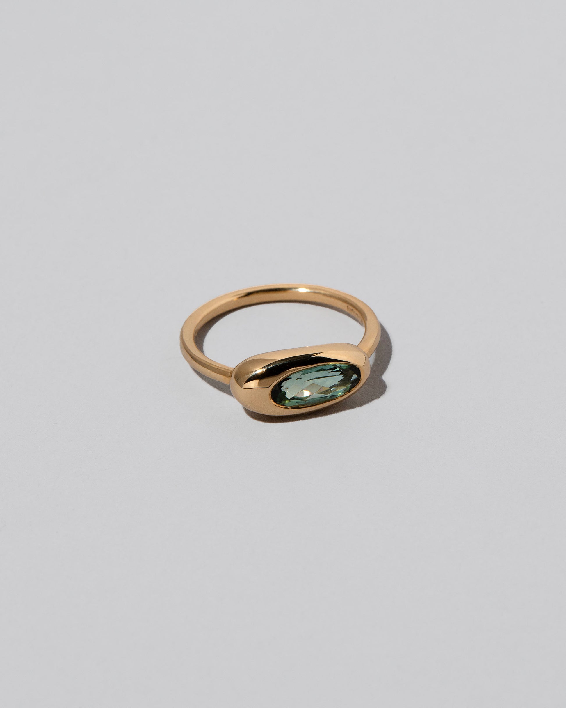 View from the side of the Tourmaline Equalize Ring on light color background.