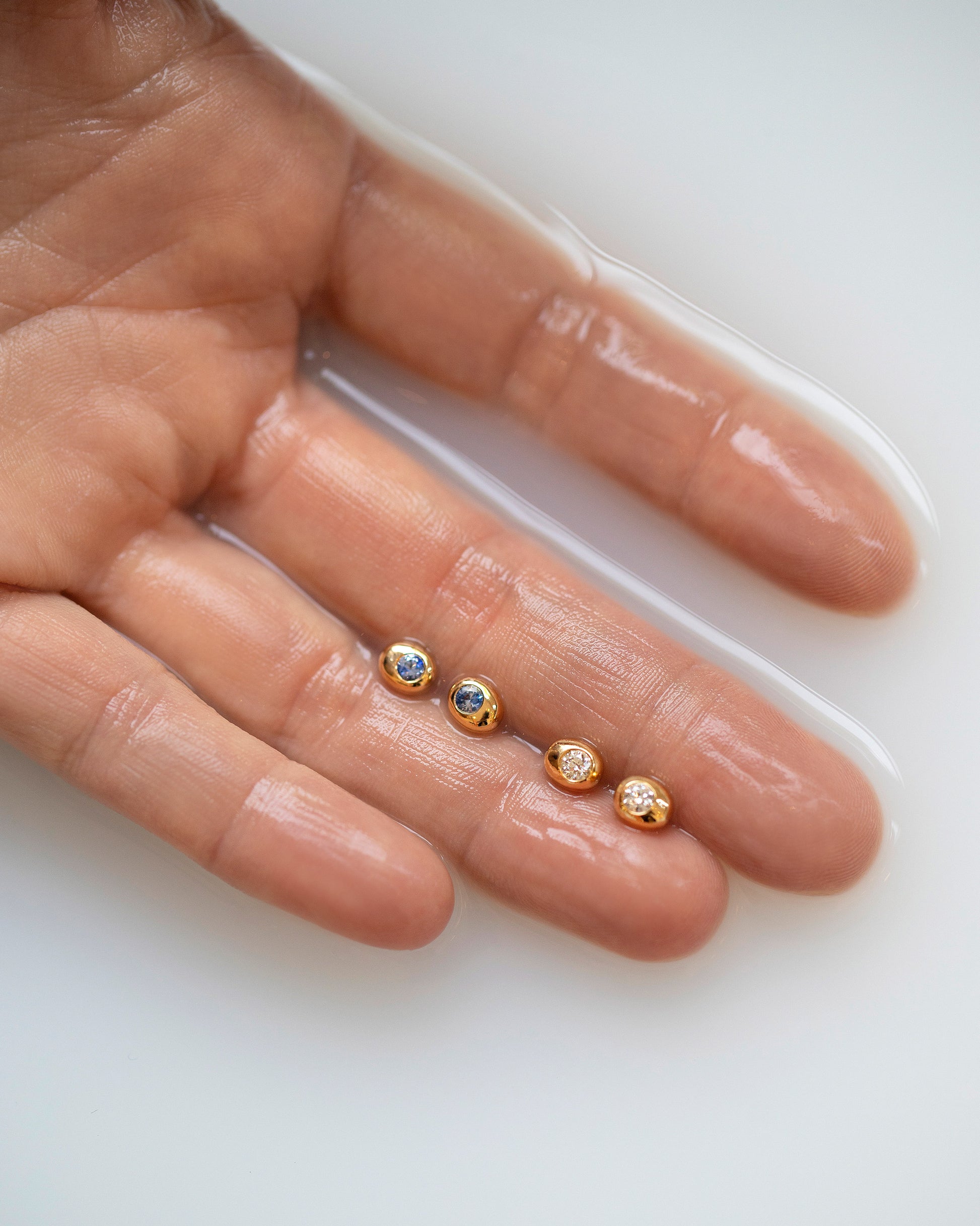 Styled image featuring the Diamond and Sapphire Birthstone Level Stud Earrings.