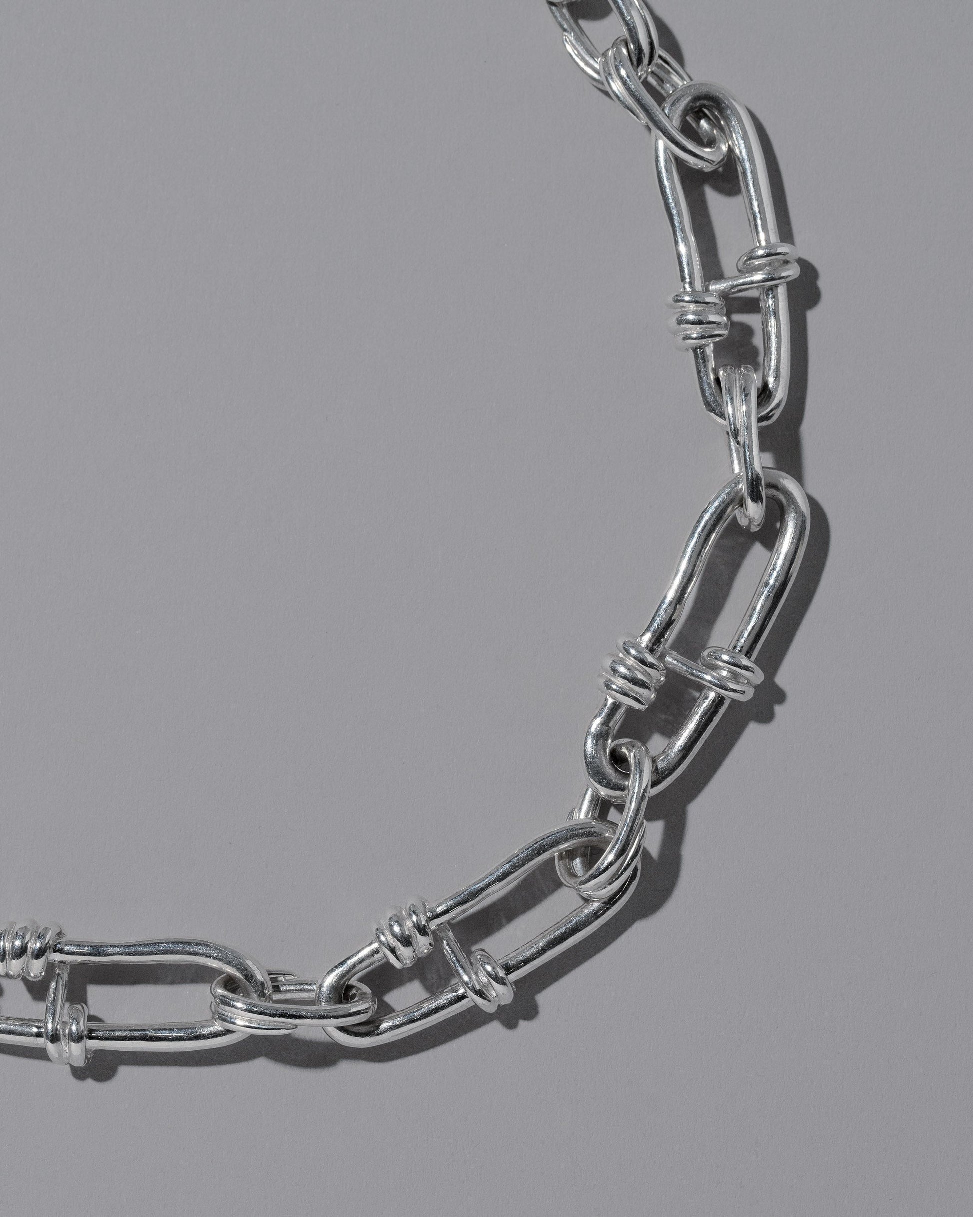 Closeup details of the CRZM Sterling Silver Canyon Necklace on light color background.