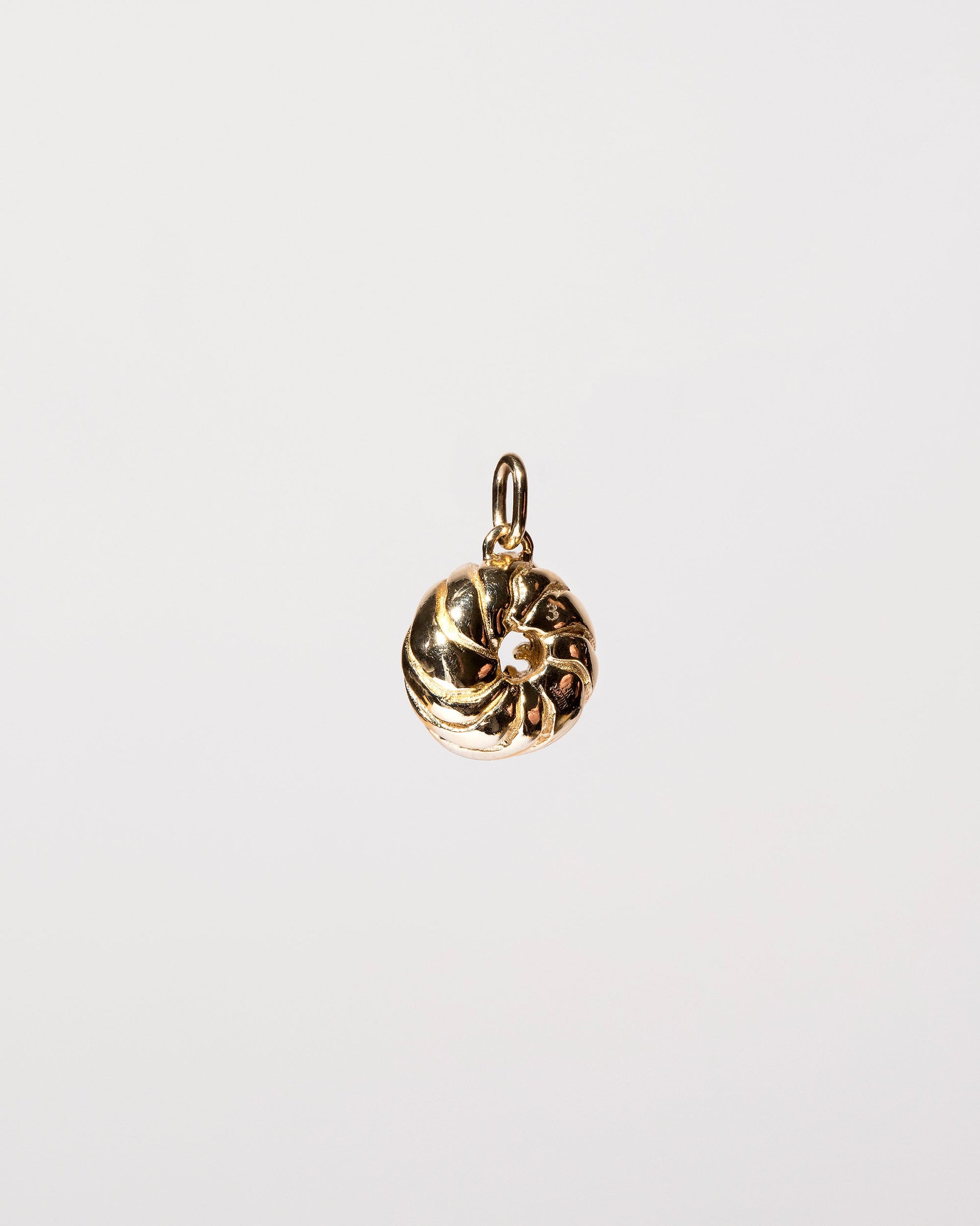 View from the side of the  French Cruller Charm on light color background.