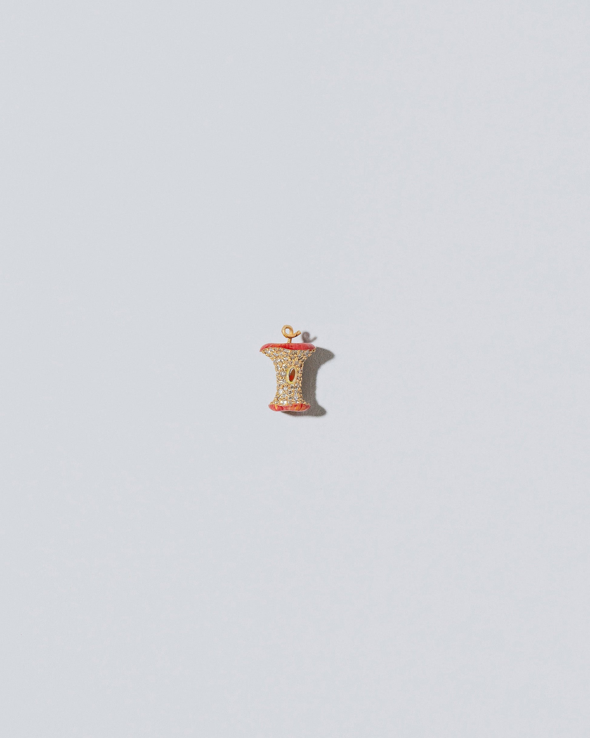 Red Apple Core Charm on light color background.