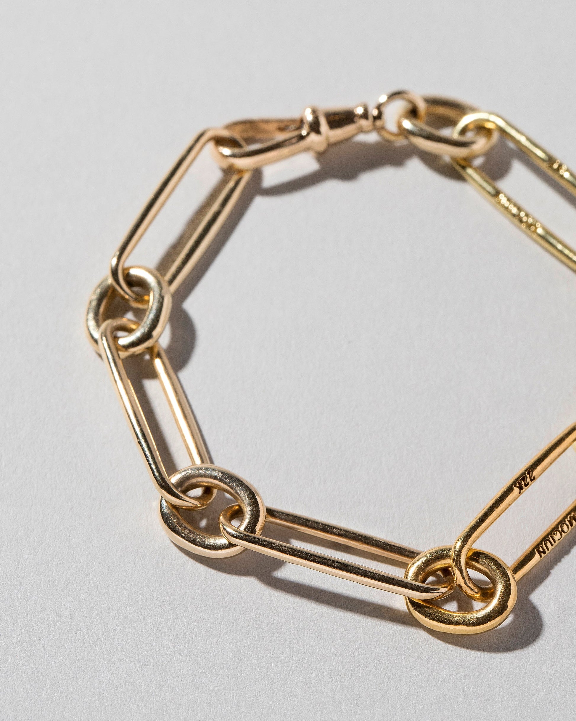 Closeup details of the Mixed Karat Link Bracelet on light color background.