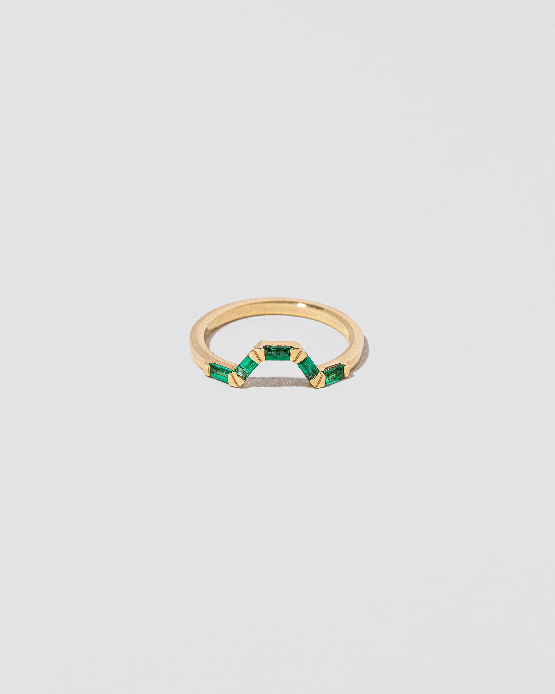 Emerald Baguette Bridge Band on light color background.