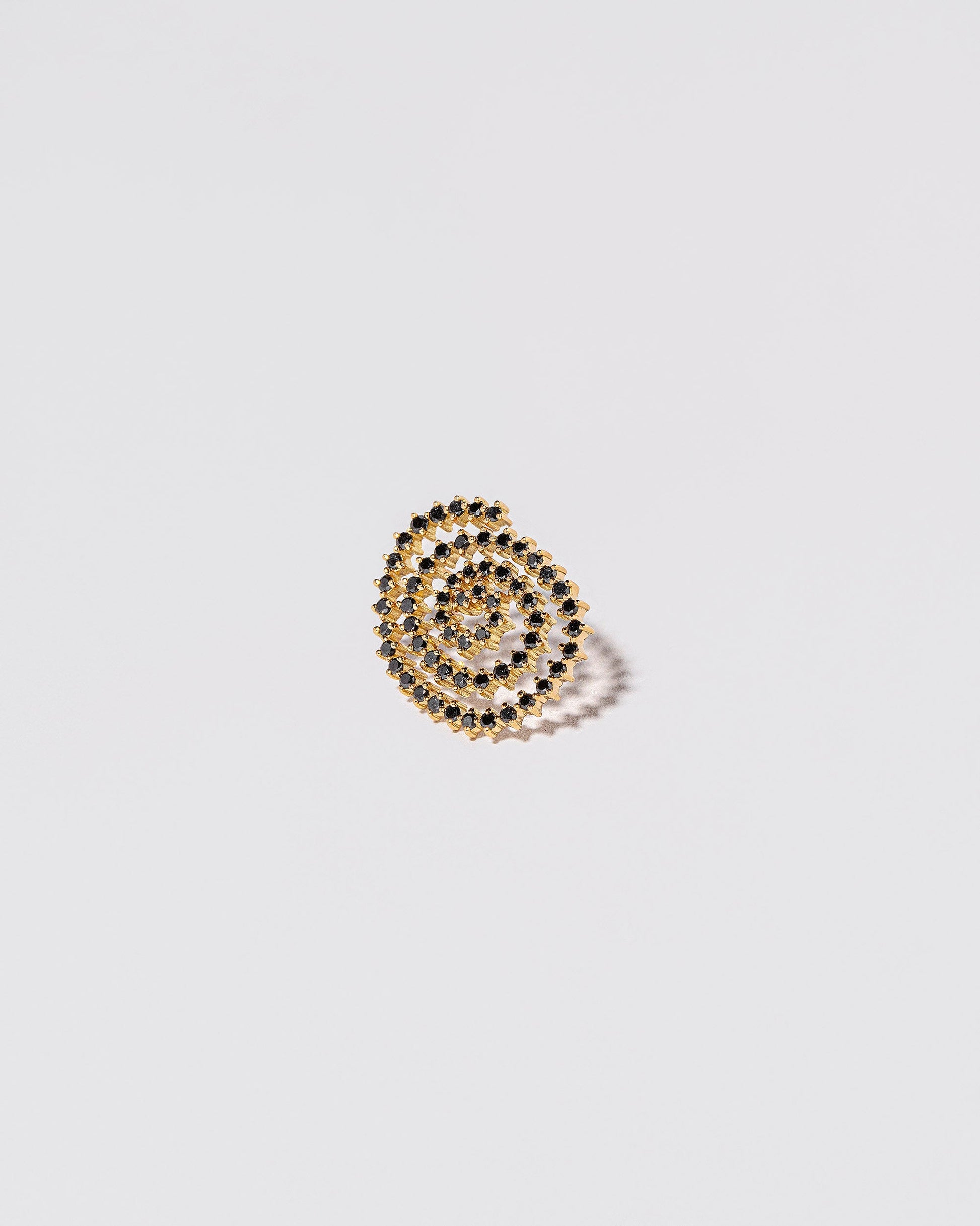 Closeup details of the Right Black Diamond Cycle of Rebirth Earring Single on light color background.